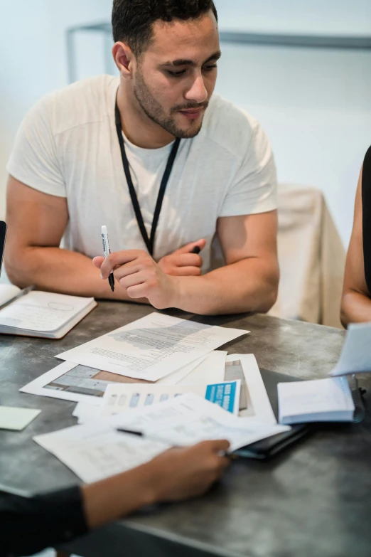 two people sit at a table with papers on it