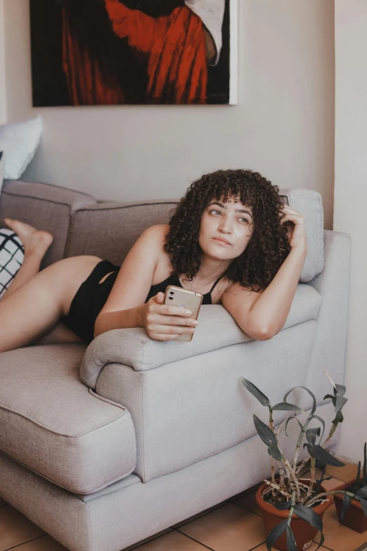 a beautiful young woman laying on top of a couch