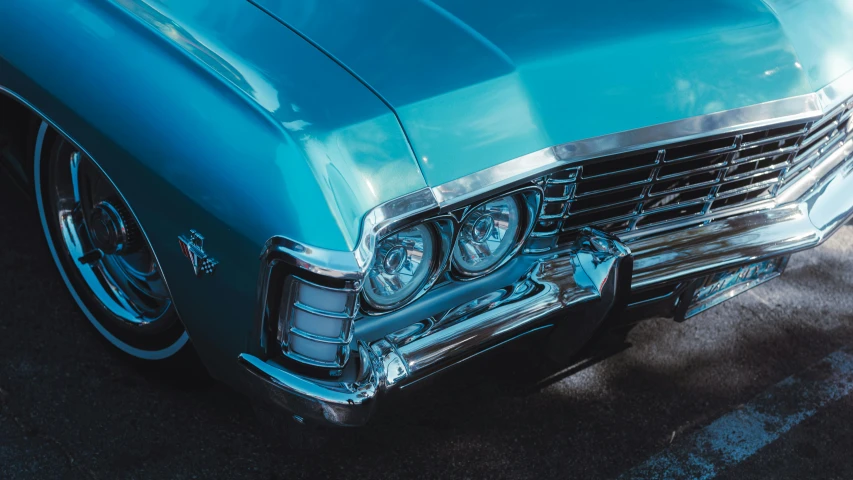 the front end of an old blue car with chrome detailing