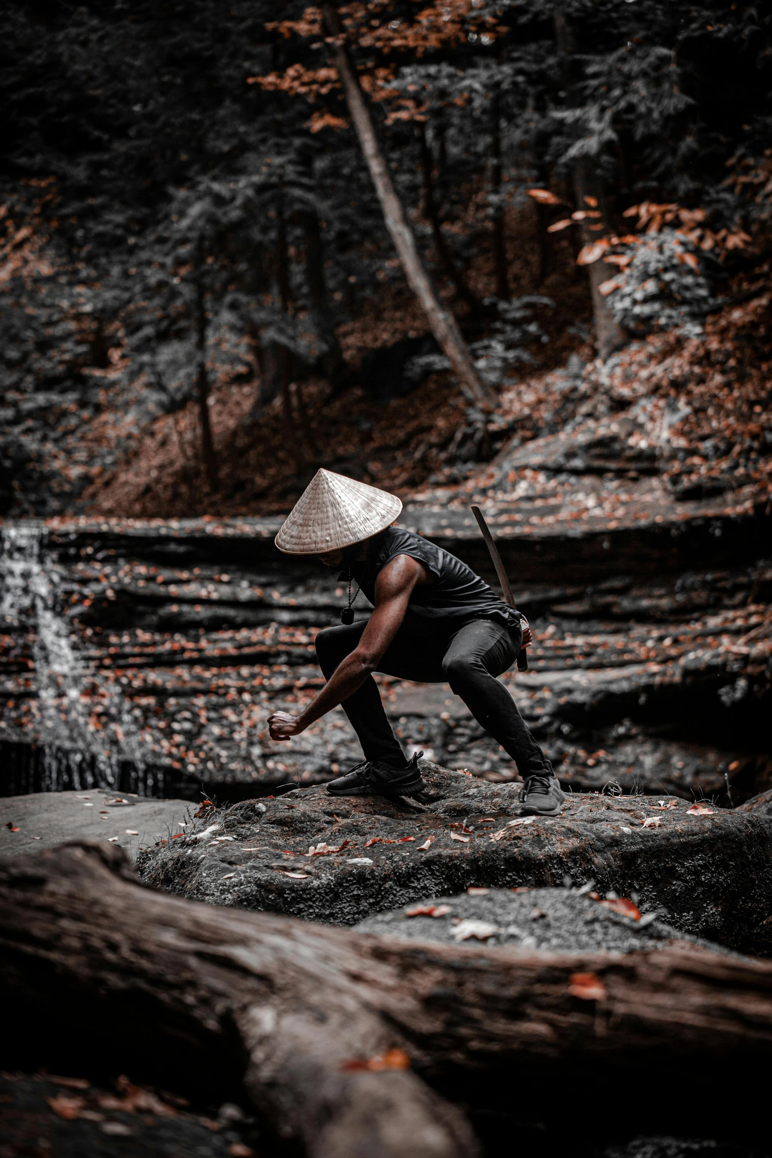 the person is climbing over some trees wearing a hat