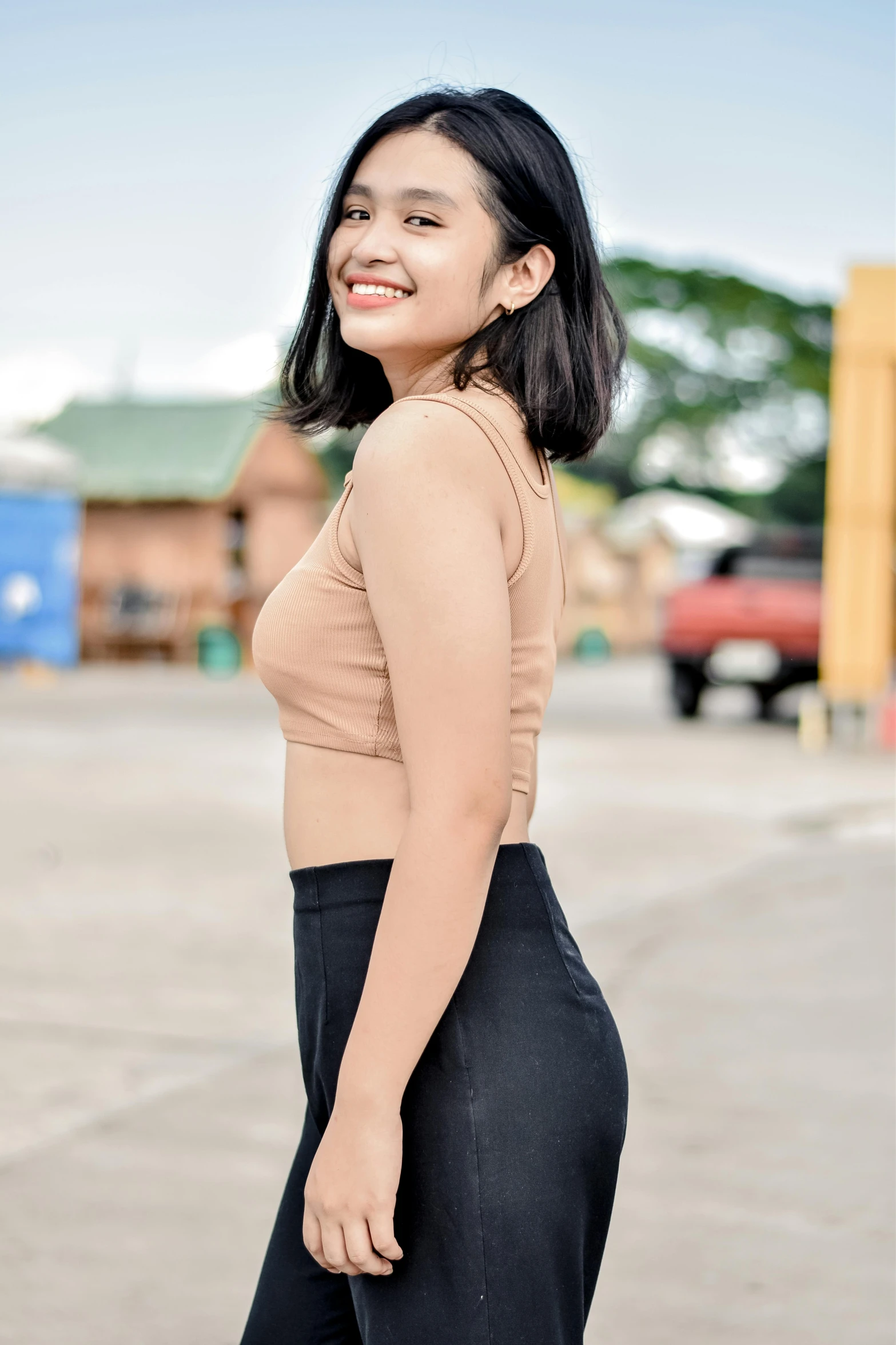 an asian woman in black slacks poses for the camera