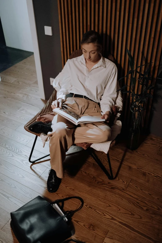 a man reading a book on a foldable chair