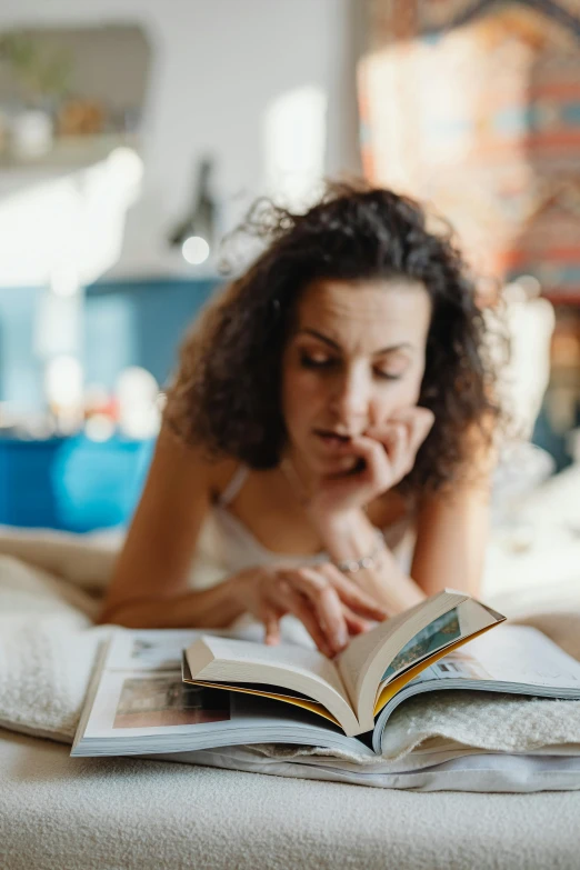 woman reading a book on the bed