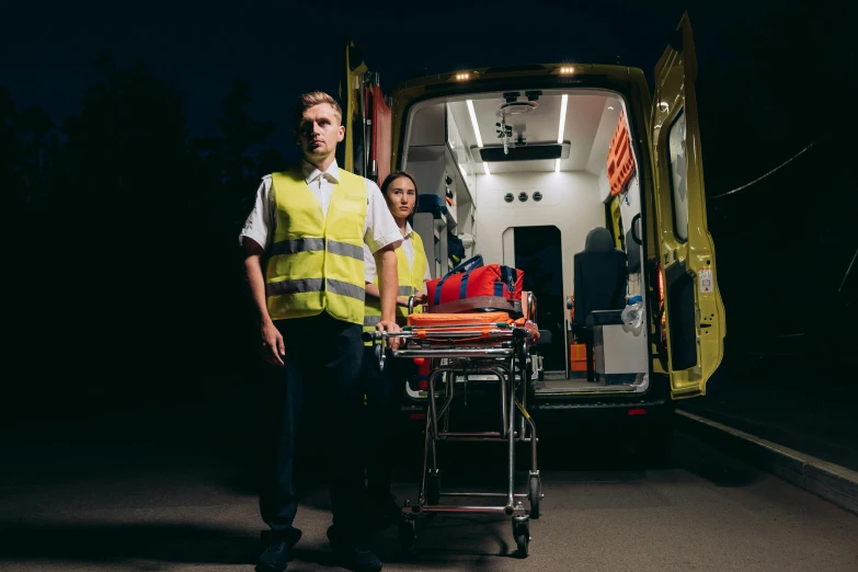 two people standing next to an ambulance in the dark