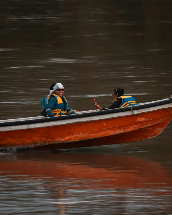 two men sitting in a canoe while talking