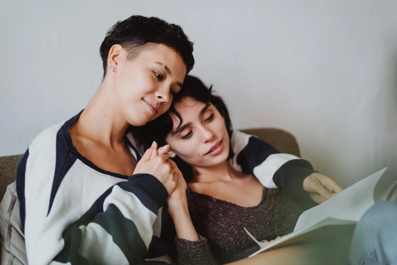 a man helping a woman with her hair while using an electronic device