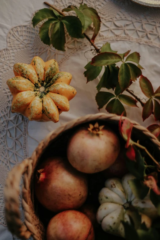 a table with several apples in baskets and some leaves