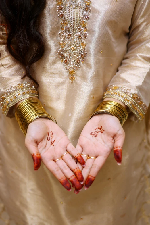 a woman wearing gold holding her hands open