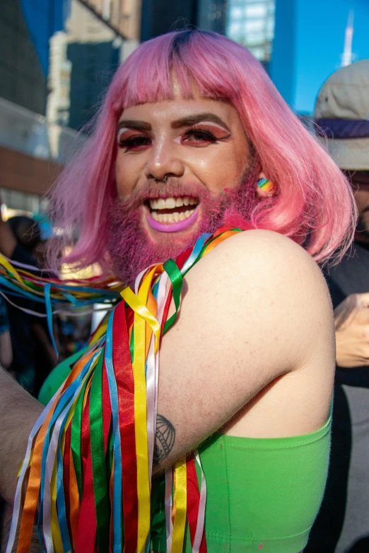 a person with bright pink hair and multi - colored ribbons