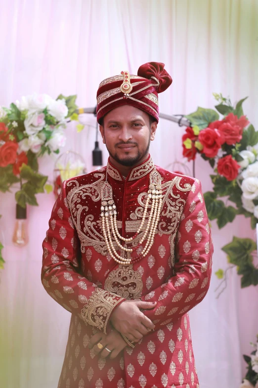 an indian man is dressed in red and gold