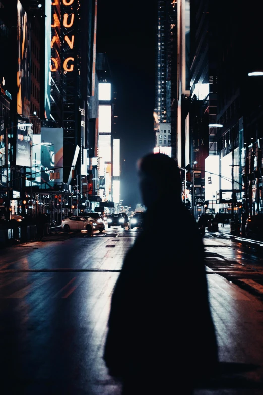 a person walking down a street with tall buildings in the background