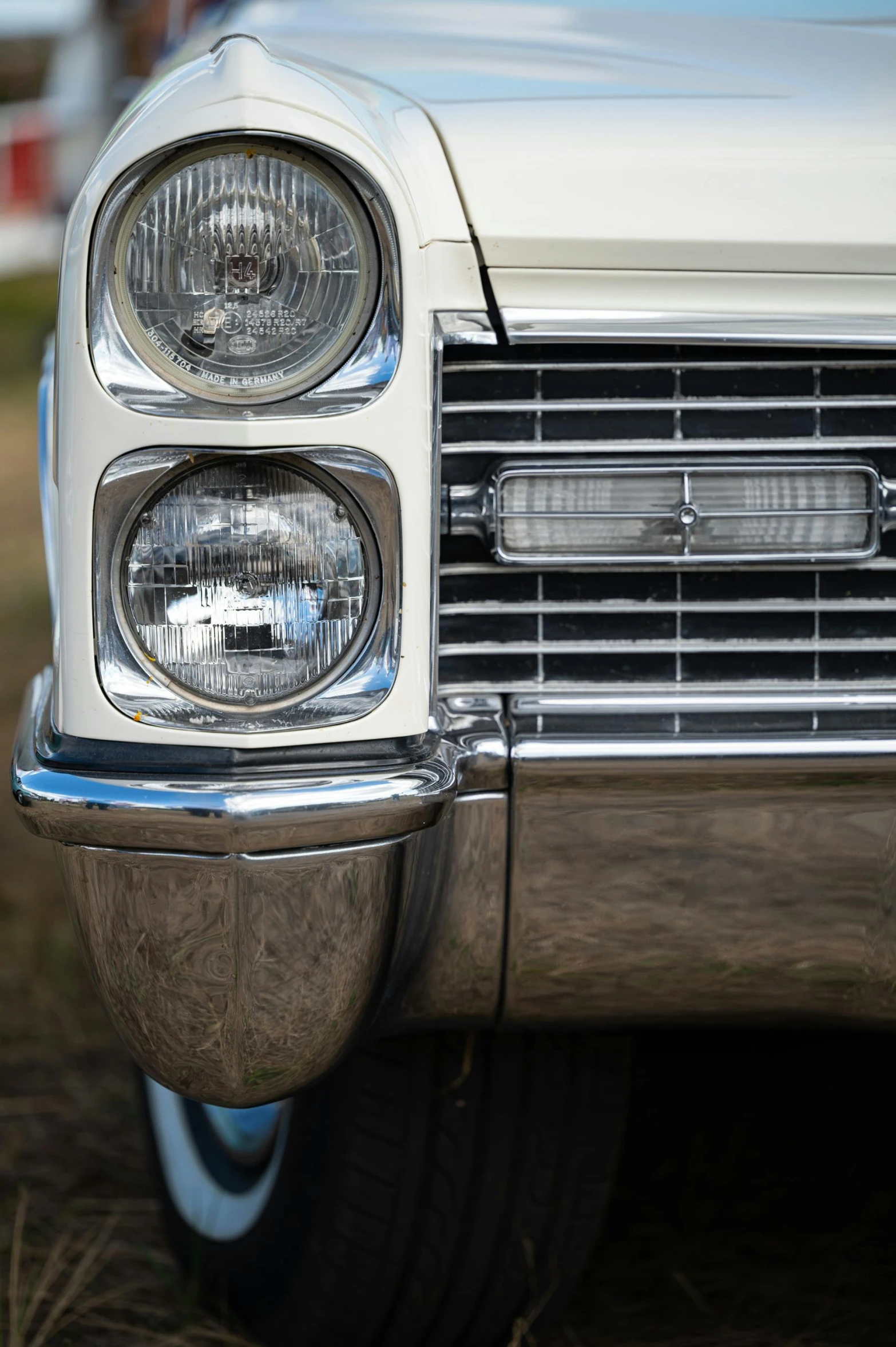 the front end of an old car with its headlights on