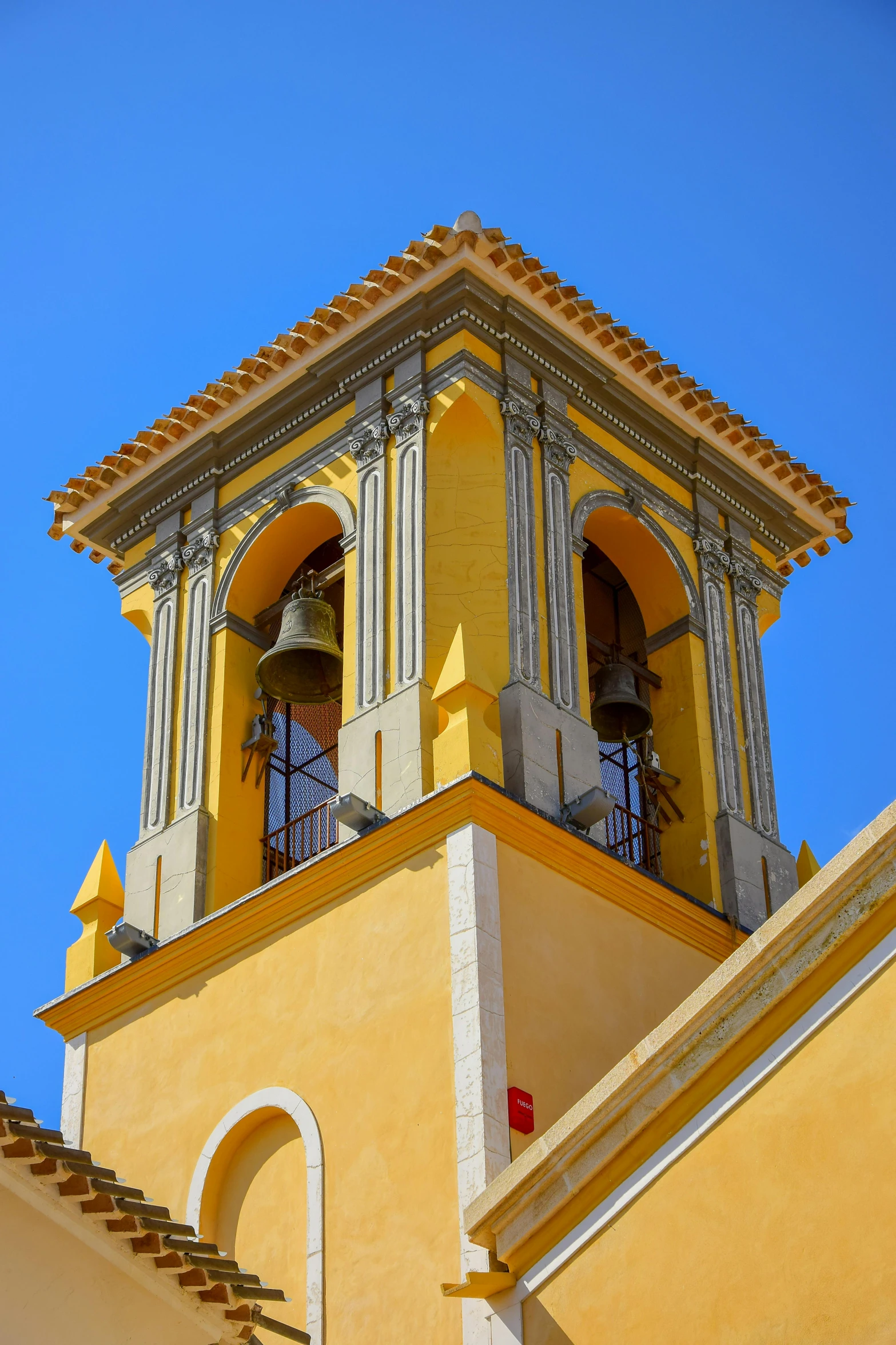 two bell towers on top of a yellow building