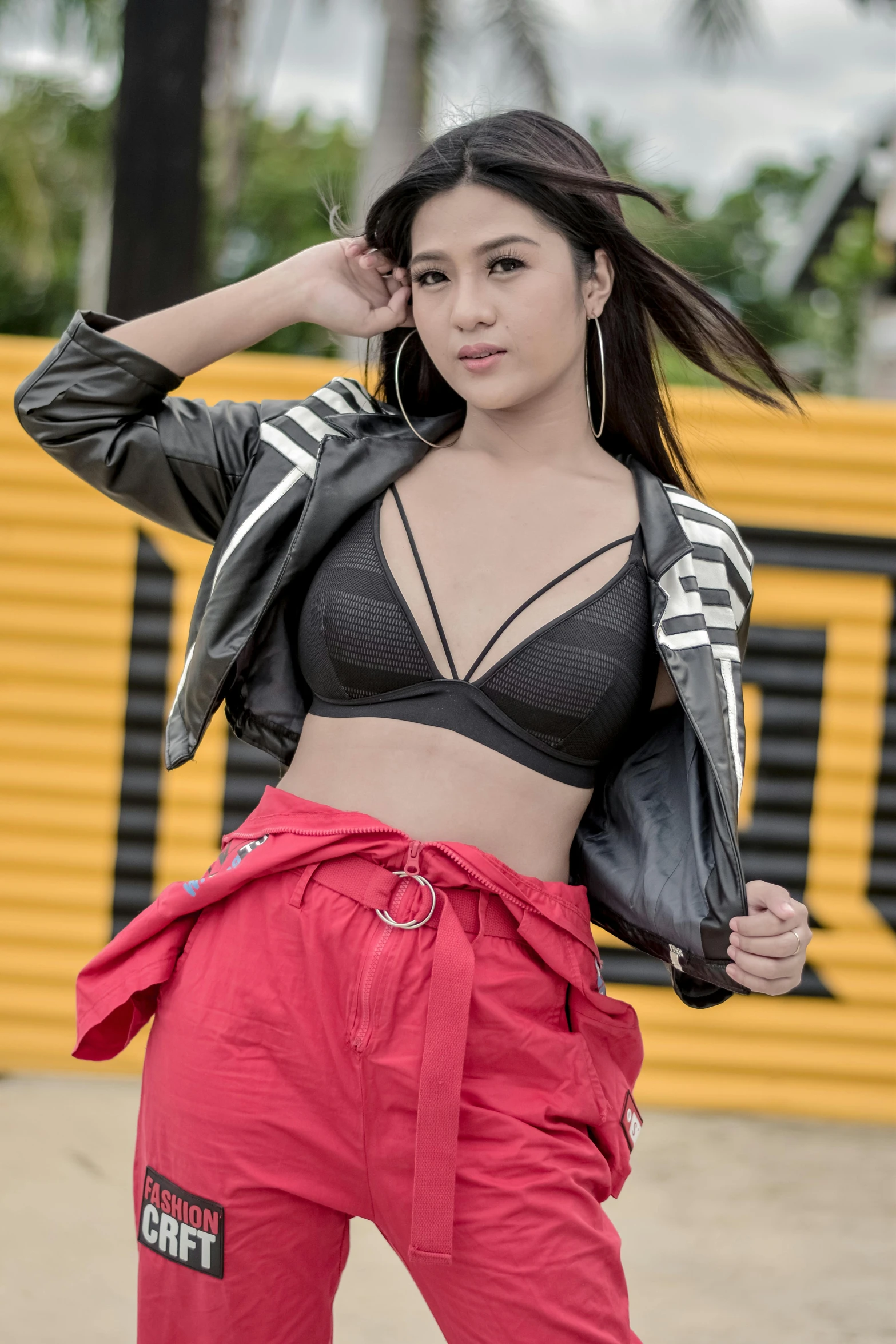 an asian woman wearing black and red pants and jacket