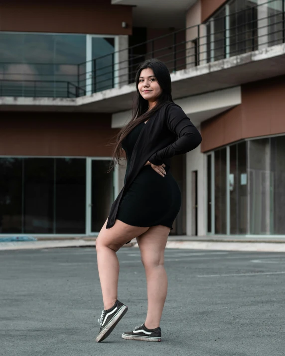 a woman posing outside of an apartment building