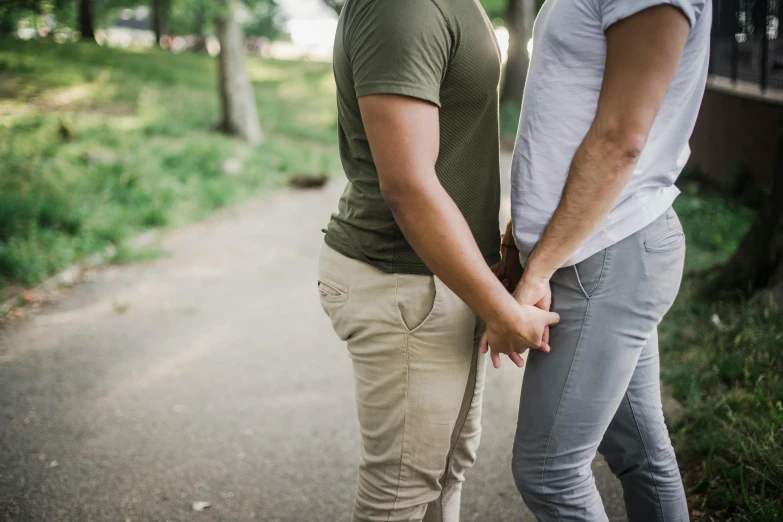 two people standing on the side walk looking towards each other