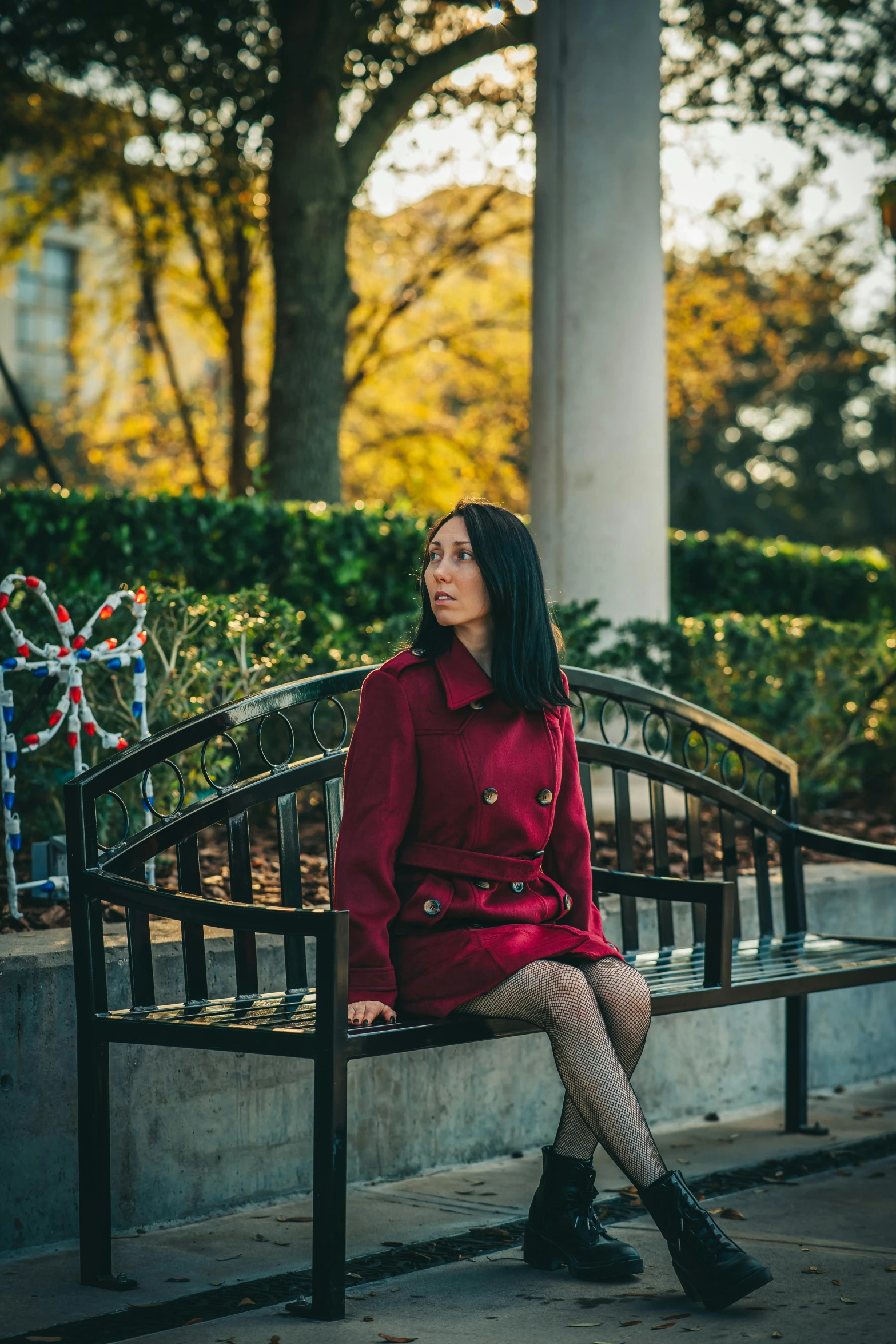 a woman in red sits on a bench with some christmas ornaments