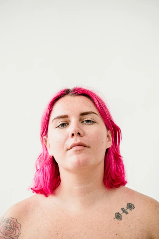 a women with pink hair has pink, frizzy locks on her chest