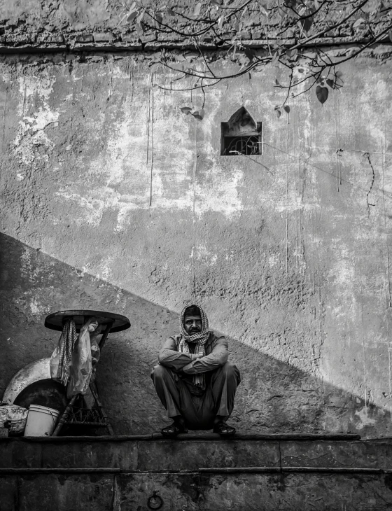 a man sitting on the side of a building