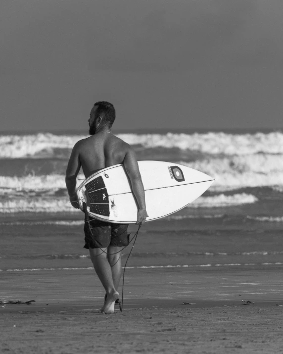 a man with a surfboard is standing in the sand