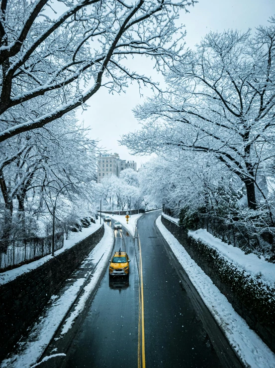 a car drives along the snowy road during the day