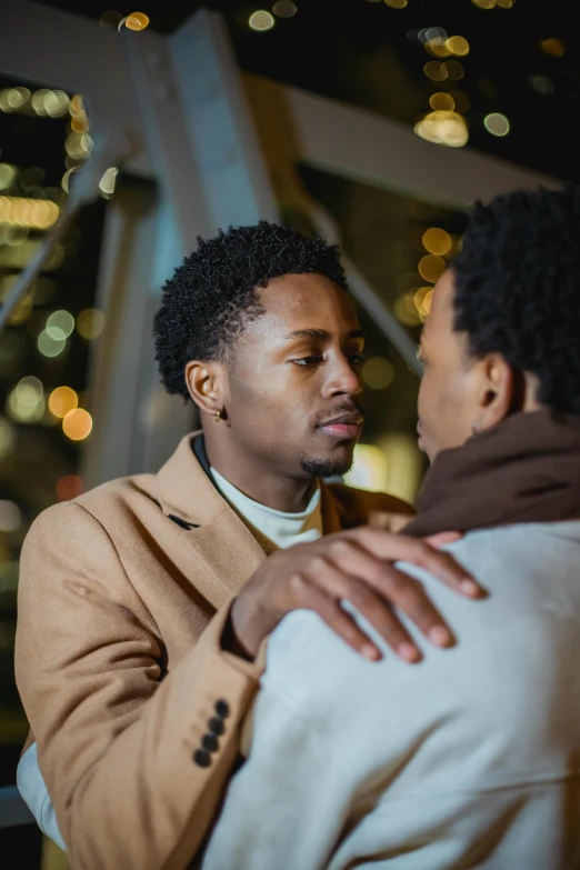 a man hugs another mans chest and looks at him