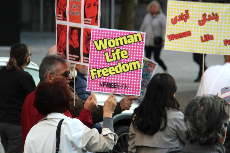 a group of people are holding signs and posters