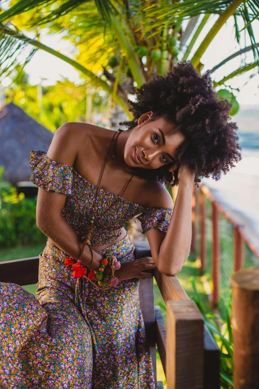 a young woman with afro hair sitting on a porch