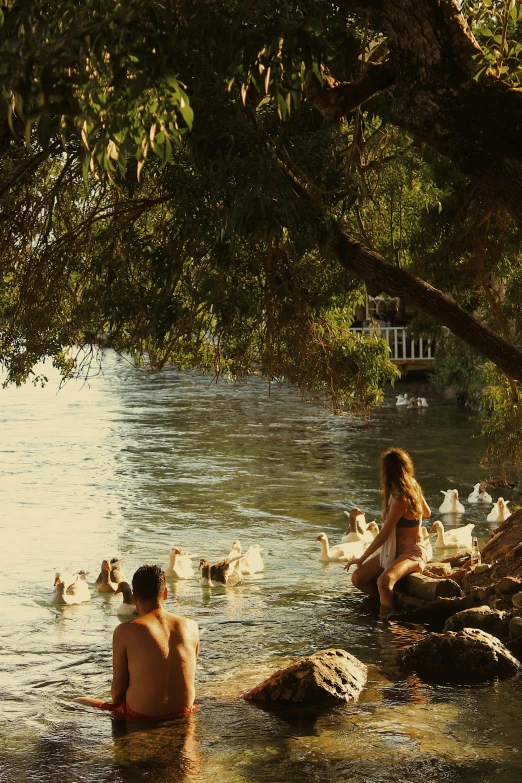 a boy and girl who are sitting in the water