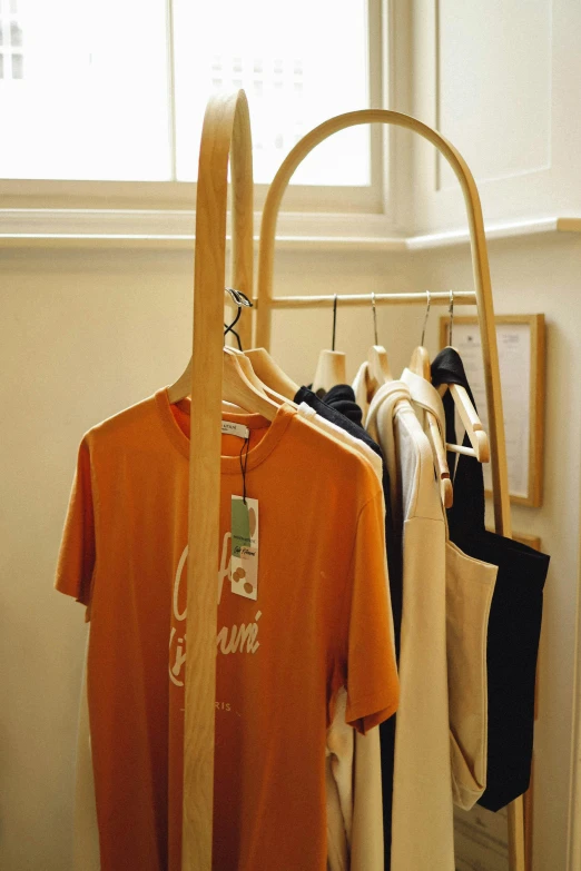 a clothes rack with multiple t - shirts and pants hanging in it