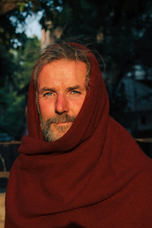 a man wearing a red shawl and beard
