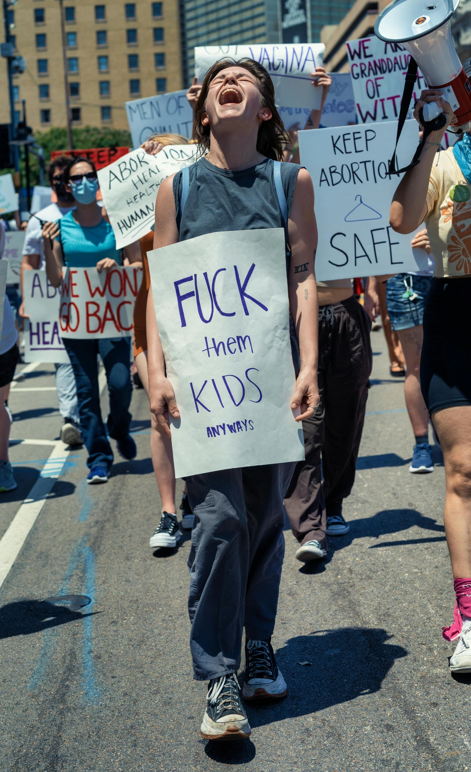 a group of protesters walking through the streets with signs