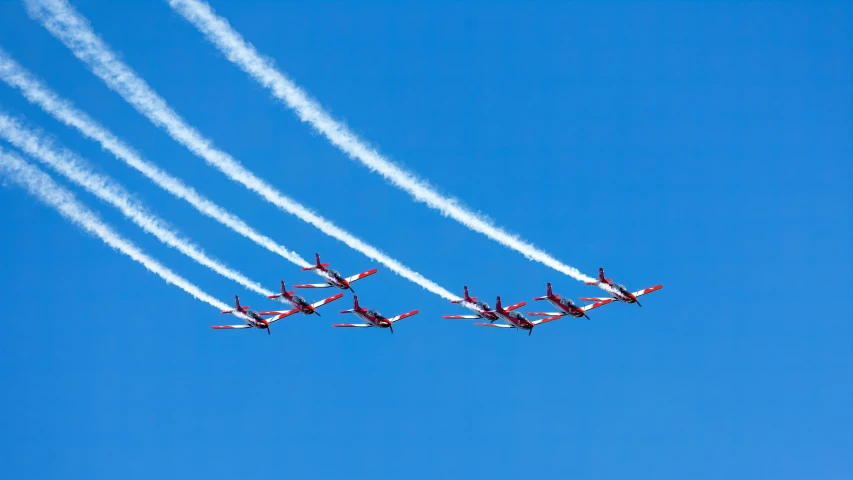 four jets fly side by side through the sky