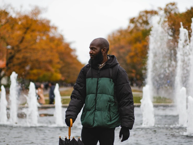 a person holding an umbrella near a water fountain