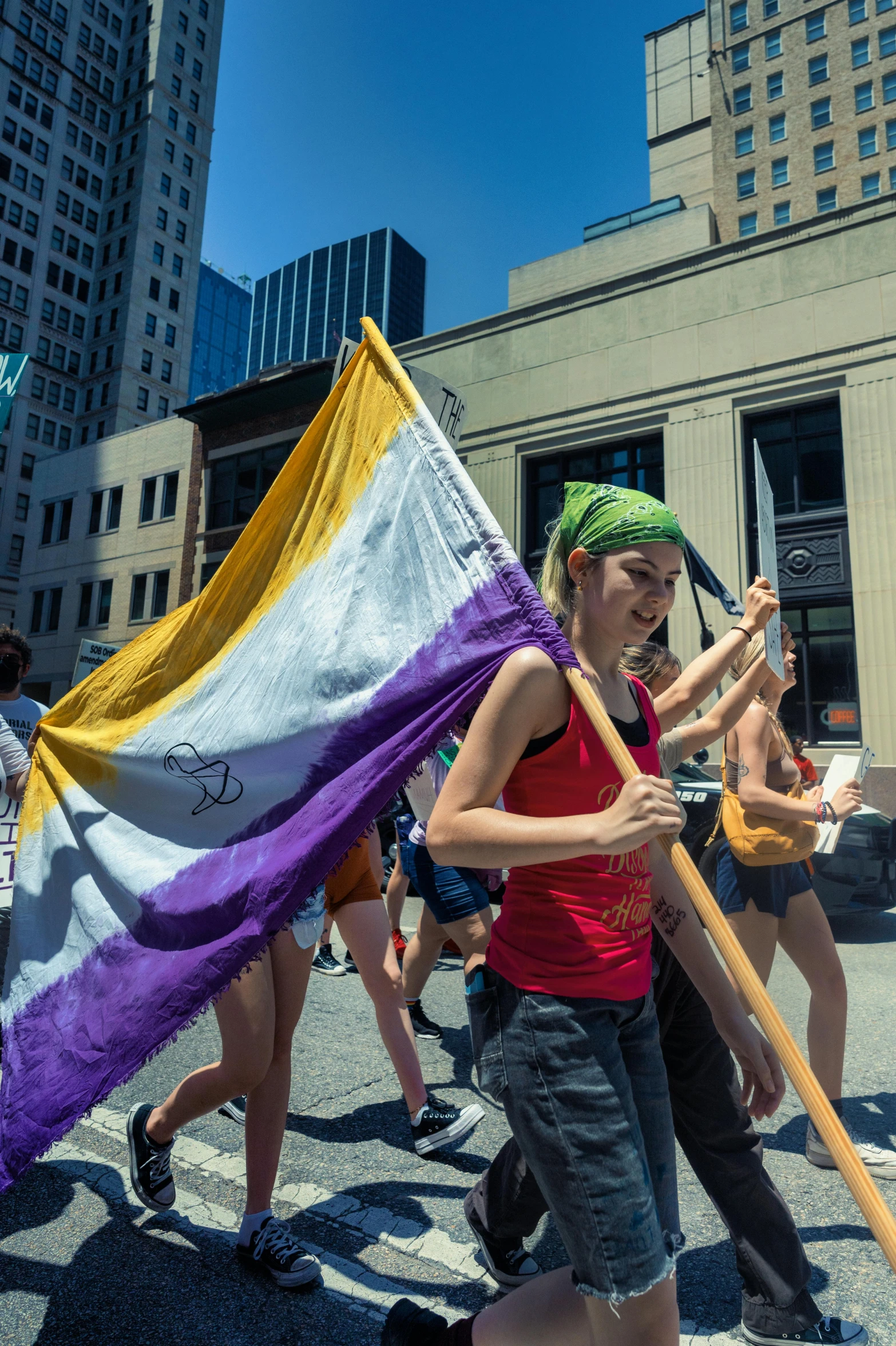 a  holds a flag and sticks a wooden pole