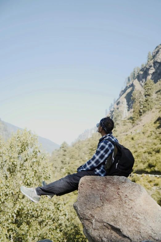 a man looking out over trees and mountains