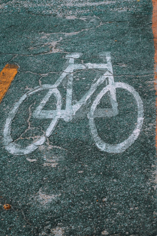 white bicycle written on road with yellow traffic light