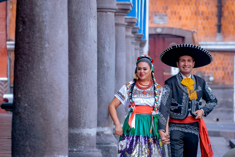 two people in traditional dress posing for the camera