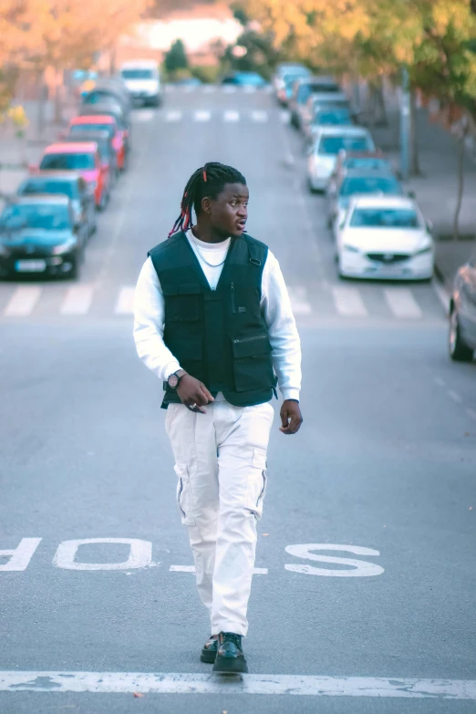 man walking on street while cars sit parked in a row