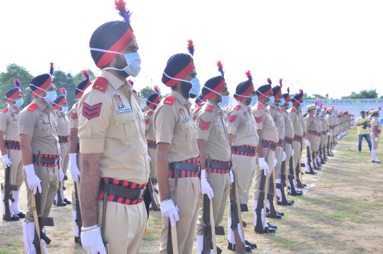 men in uniforms and masks marching down a field