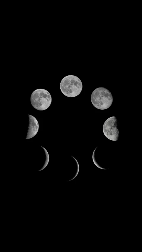 phases of the moon taken from a distance in the dark night sky