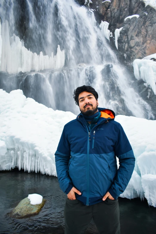 a man standing in front of a water fall