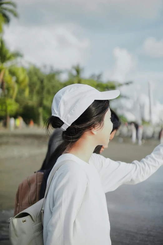 the woman in white is holding up a large object