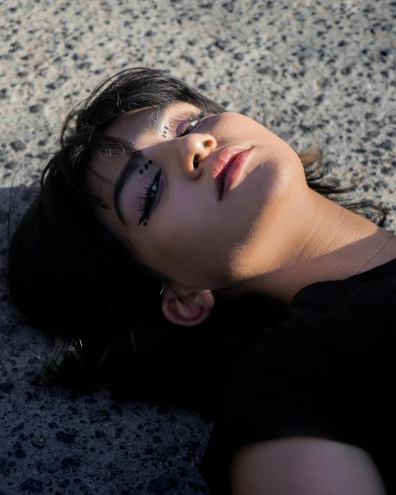 a woman laying on the ground with her eyes closed