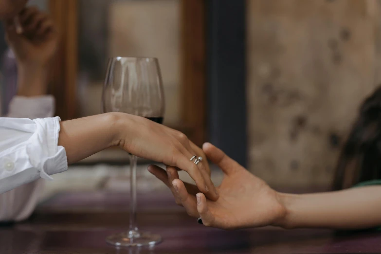 bride and groom in white dress holding hands near wine glass