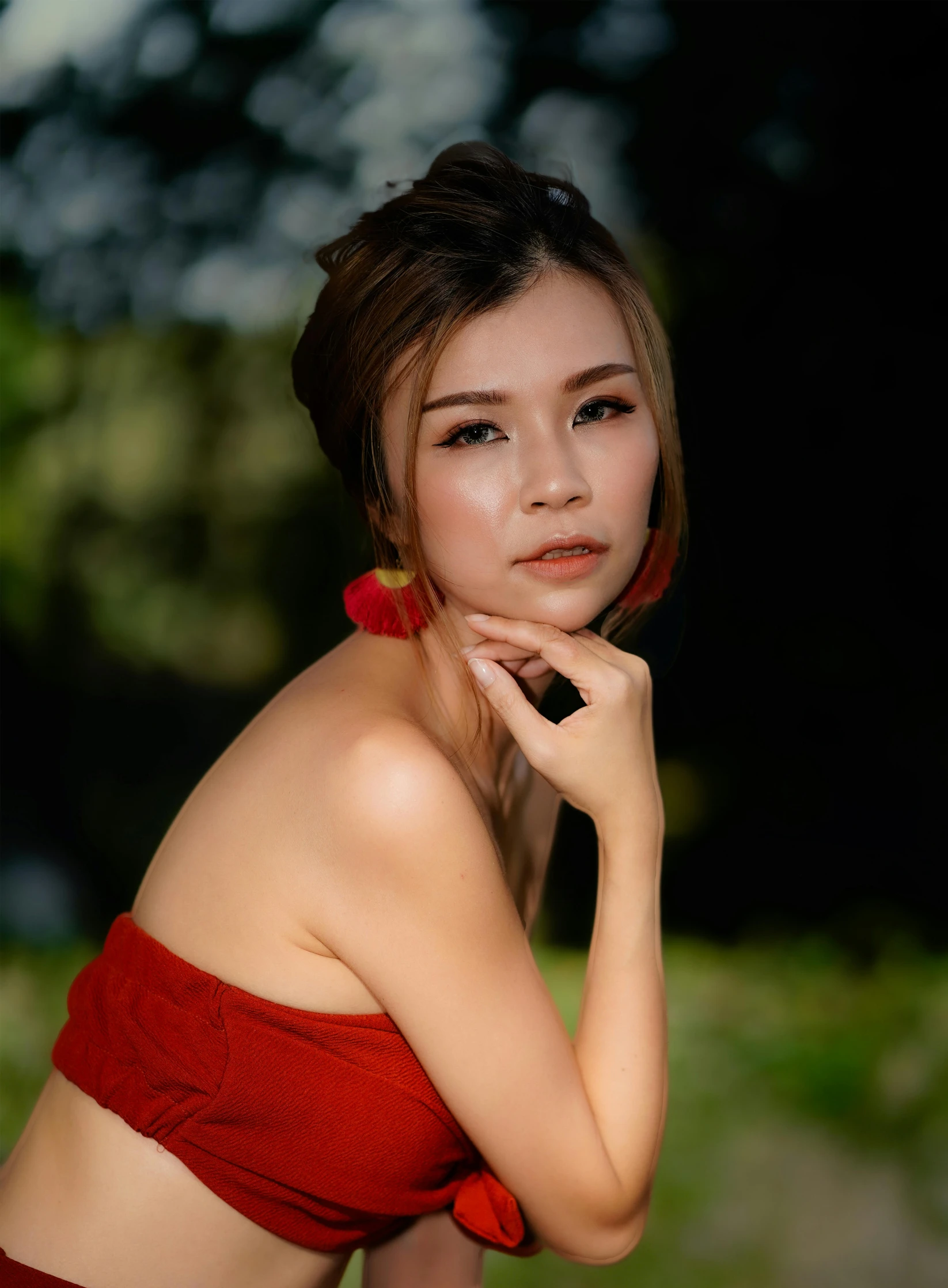 a woman in a red strapless top posing for a portrait