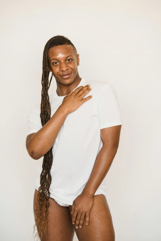 an african american man in a white shirt poses with his hand on his hips