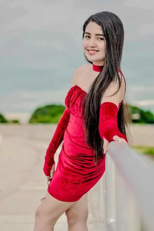 a girl posing for the camera while in a red dress