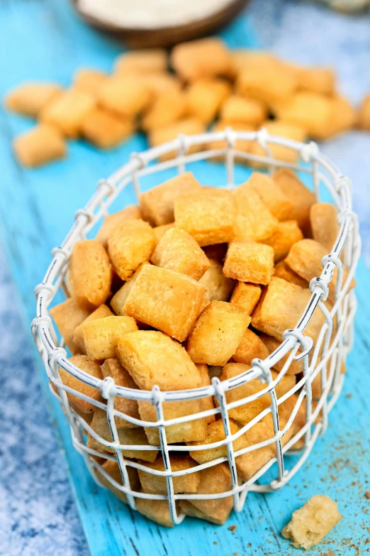 a bowl full of small tofu on blue wood