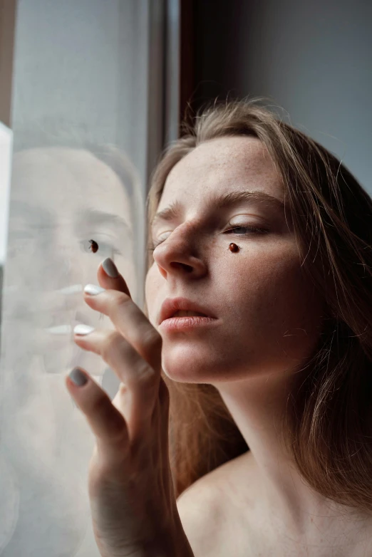 a beautiful woman wearing makeup holding a cigarette